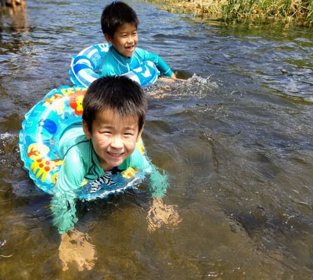 男の子が2人川で水遊びをしている